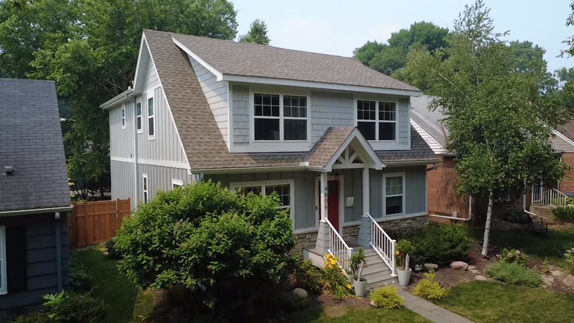 A blue two-story Twin Cities home with a new Stoneridge roof