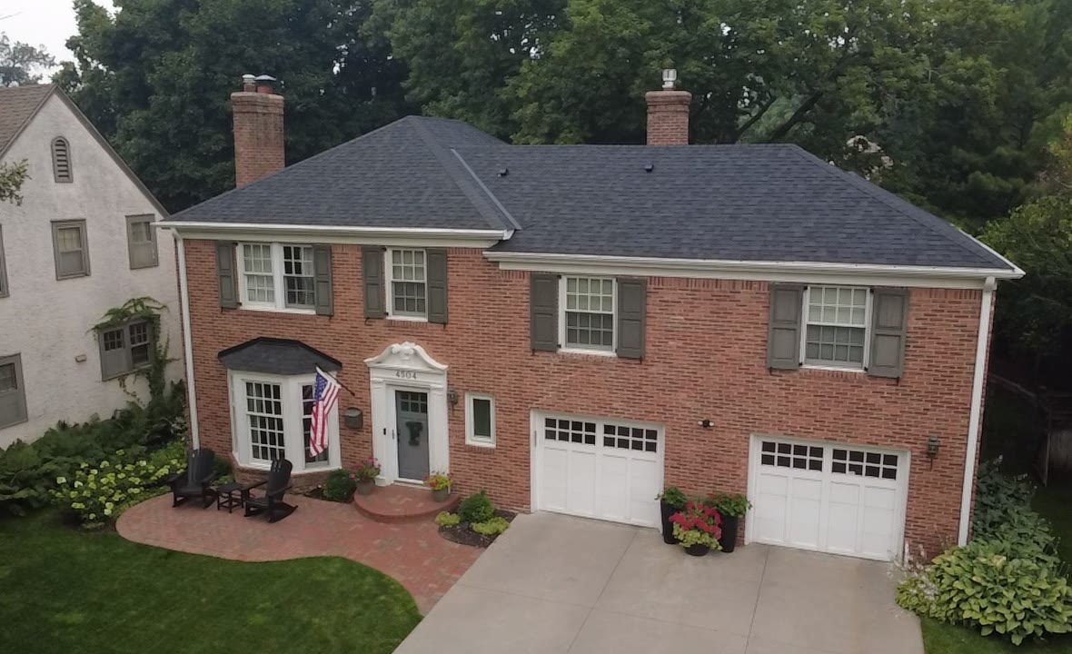 A two-story brick home in the Twin Cities with a new dark Stoneridge roof